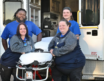 This is a picture of some ems staff in front of the ambulance.